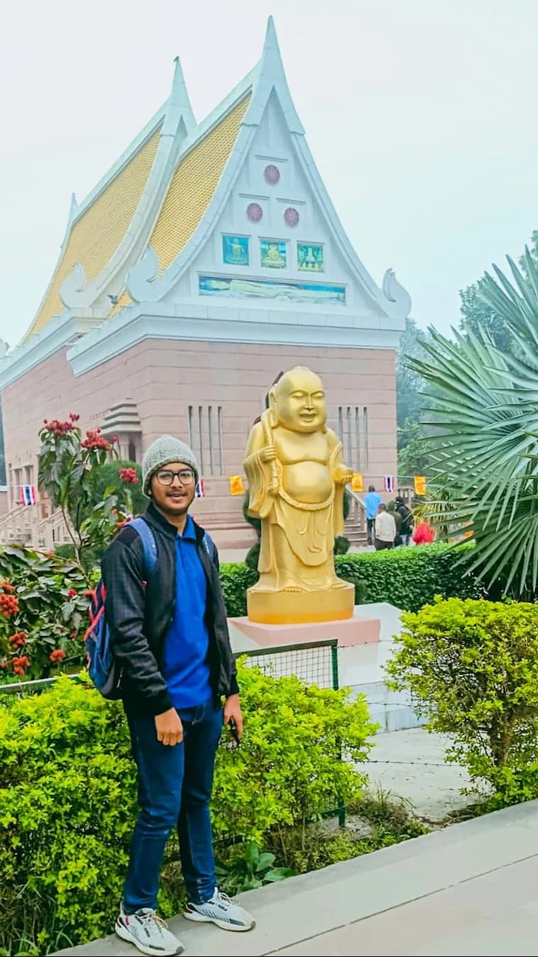 Gantavya in front of a temple with a golden statue